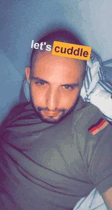 a man laying on a bed with a yellow sticker on his head that says " let 's cuddle "