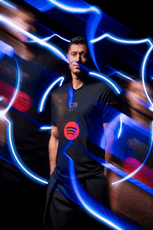 a man wearing a black shirt with a red spotify logo on it