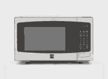 a stainless steel microwave oven is sitting on a white table .