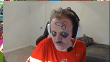 a man wearing headphones has a penis drawn on his face