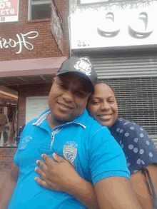 a man and woman are posing for a picture in front of a store that says ' i & o ' on it