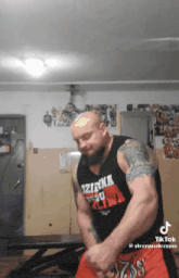 a man with a tattoo on his forehead is wearing a tank top that says ' iztacka ' on it