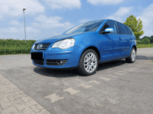 a blue volkswagen polo is parked on the side of the road