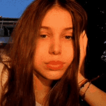 a close up of a woman 's face with long brown hair covering her ears .