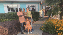 a family standing in front of a blue building