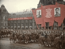 a group of horses are marching in front of a building with a banner that says " lenin " on it