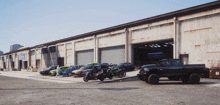 a ram truck is parked in front of a building with cars parked in front