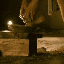 a person is lighting a candle in a bowl