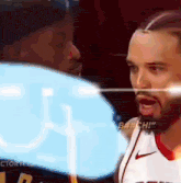 a man in a nike jersey is yelling at another man in a black hat