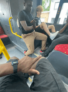 a man wearing a watch that says casio on it sits on a bus