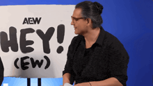 a man is standing in front of a sign that says hey