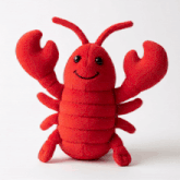 a stuffed red lobster with a smiling face on a white background