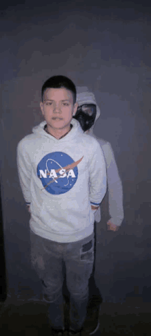 a man wearing a nasa hoodie is standing next to another man