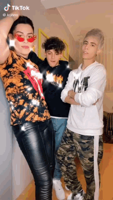 three people are posing for a picture and one of them has a tiktok account