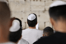 a man wearing a yarmulke sits in a crowd