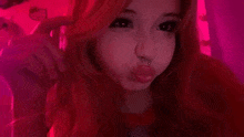 a girl with red hair and a nose ring is making a face in a pink room .