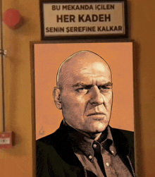 a picture of a bald man under a sign that says " bu mekanda icilen her kadeh senin serefine kalkar "