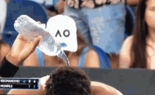 a bottle of water is being poured into a man 's head during a tennis match between kechamovic and monfils