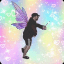 a man with fairy wings is holding a wand in his hand .