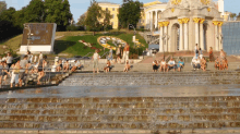 a group of people sit on the steps of a waterfall in front of a sign that says ' ukraine ' on it