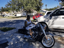 a man sitting on a harley davidson motorcycle looking at his phone