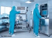 two men in clean suits are working in a lab .