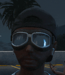 a man wearing a hat and goggles is standing in front of a palm tree