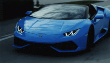 a blue lamborghini sports car is driving down the road
