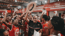 a man holding a hat in front of a banner that says presidente jose carlos monal