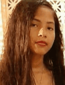 a close up of a young woman 's face with long hair and red lips .