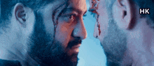 two men face to face with blood coming out of their eyes