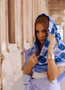 a woman wearing a purple dress and a blue scarf around her head
