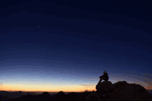 a person sitting on top of a mountain looking at the sky