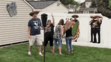 a man in a blue shirt with the letter w on it stands next to a woman in a sombrero