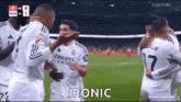 a group of soccer players are hugging each other on a field and one of them is saying `` ironic '' .