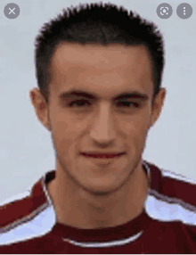 a close up of a man 's face with a red and white striped shirt