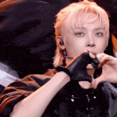 a man with blonde hair is wearing a black glove
