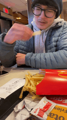 a man eating french fries in a mcdonald 's