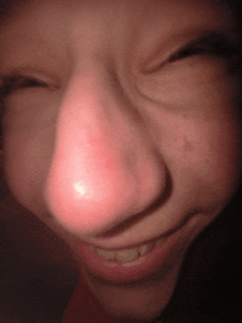 a close up of a person 's face with a glowing red nose