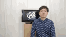 a man stands in front of a tv that says u40 on it