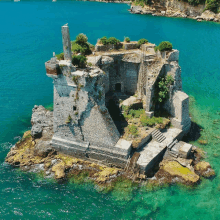 an aerial view of a castle on a small island in the middle of a body of water