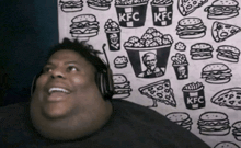 a man wearing headphones looks up at a kfc poster