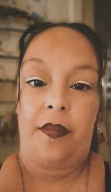 a close up of a woman 's face with red lips and white eye shadow