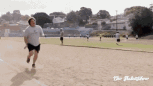 a man in a white shirt is running on a track in front of a sign that says der studentenführer