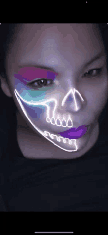 a woman with a skull painted on her face looks at the camera