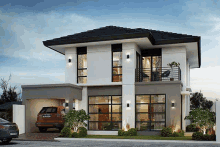 a modern house with a car parked in front of it and a balcony .