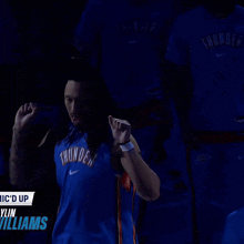a man in a blue thunder jersey stands in front of a sign that says " in williams "