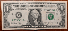 a one dollar bill from the united states of america is laying on a wooden table