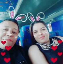 a man and a woman are sitting on a bus with hearts around them and the word love written in pink