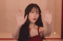 a woman in a red dress is making a stop sign